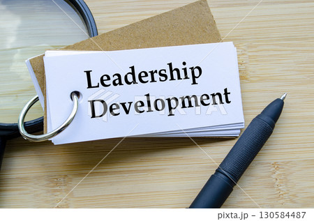 Leadership Development, Notepad labeled Leadership Development with ladder leaning against it in conceptual design. 130584487