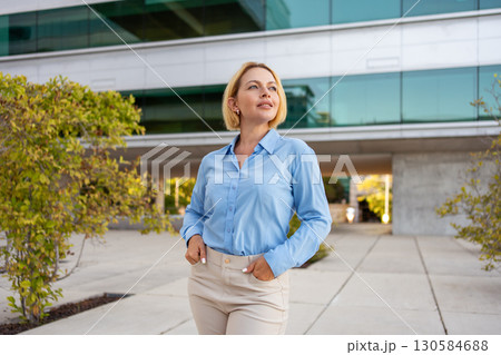 Thoughtful businesswoman standing with hands in 130584688