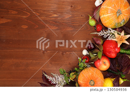 Thanksgiving, autumn background with seasonal autumn nature berries, pumpkins, apples and flowers on a wooden background, top view, copy space, flat lay. Happy Thanksgiving concept, selective focus. Thanksgiving, autumn background with seasonal autumn nature berries, pumpkins, apples and flowers on a wooden background, top view, copy space, flat lay. Happy Thanksgiving concept, selective focus. 130584936