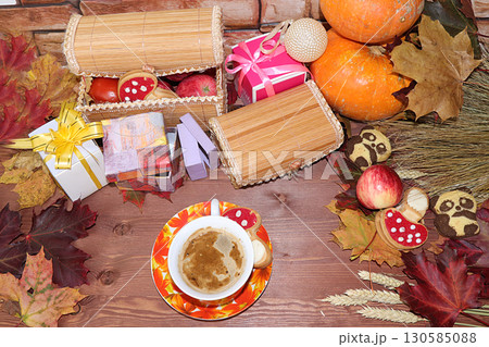Cappuccino in a cup, Thanksgiving, autumn background with seasonal autumn nature berries, pumpkins, apples and gifts on a wooden background, copy space, happy thanksgiving concept, selective focus. Cappuccino in a cup, Thanksgiving, autumn background with seasonal autumn nature berries, pumpkins, apples and gifts on a wooden background, copy space, happy thanksgiving concept, selective focus. 130585088