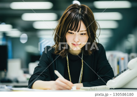電話越しに未来を築く、若きオフィスワーカー 130586180