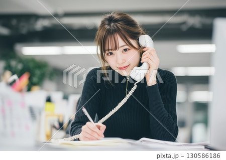電話越しに未来を築く、若きオフィスワーカー 130586186