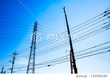 空に伸びるクレーンのアームと送電鉄塔　a-2 高彩度コントラスト 130586189