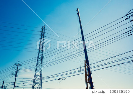 空に伸びるクレーンのアームと送電鉄塔　a-3 暖色寒色強調 130586190
