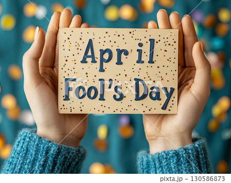 Celebrating April Fools Day with a colorful sign held by hands 130586873