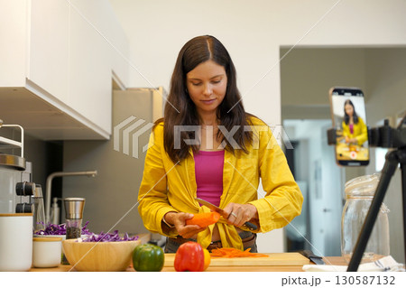 Young woman is broadcasting live from workshop how to prepare a vegetarian food Young woman is broadcasting live from workshop how to prepare a vegetarian food 130587132