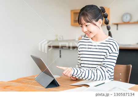 タブレットを使いながら勉強,宿題をする小学生,中学生の女の子 タブレットを使いながら勉強,宿題をする小学生,中学生の女の子 130587134