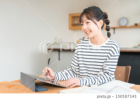 タブレットを使いながら勉強,宿題をする小学生,中学生の女の子 130587143