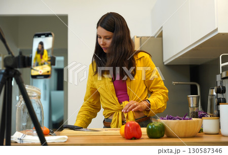 Young woman is broadcasting live from workshop how to prepare a vegetarian food Young woman is broadcasting live from workshop how to prepare a vegetarian food 130587346