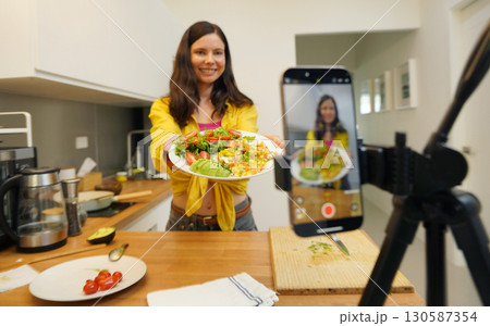 Young woman is broadcasting live from workshop how to prepare a vegetarian food 130587354