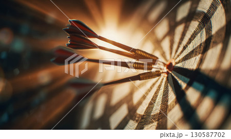 Close-up of three darts embedded in a dartboard with dramatic lighting and shadows 130587702
