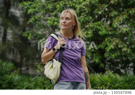 A woman is rollerblading gracefully on a road located in a park 130587896