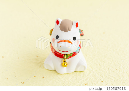 午年の可愛い年賀状素材　馬の干支置物　黄色背景 130587918