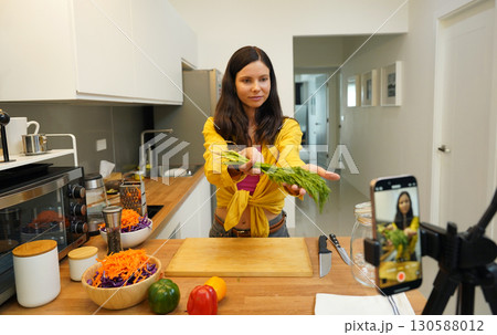 Young woman is broadcasting live from workshop how to prepare a vegetarian food Young woman is broadcasting live from workshop how to prepare a vegetarian food 130588012