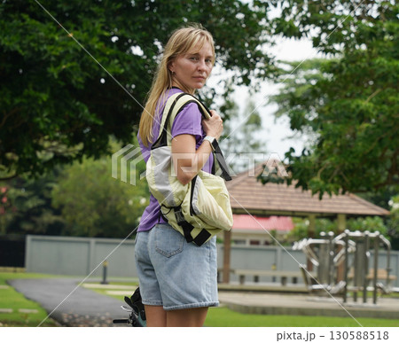 A woman is rollerblading gracefully on a road located in a park A woman is rollerblading gracefully on a road located in a park 130588518