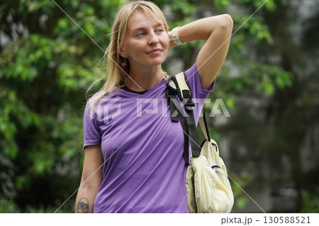 A woman is rollerblading gracefully on a road located in a park 130588521