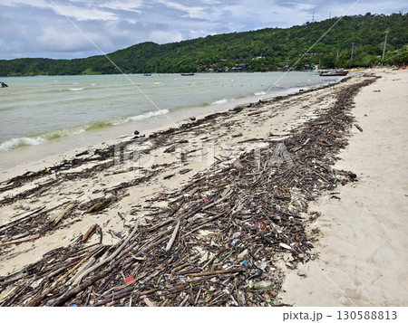 A beach heavily littered with wood and plastic 130588813