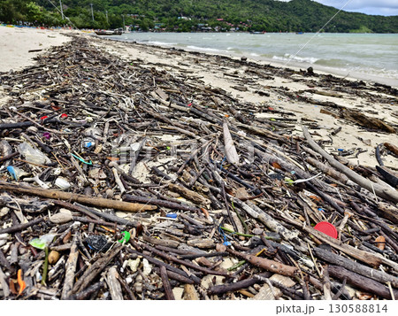 A beach heavily littered with wood and plastic 130588814
