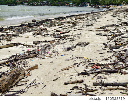 A beach heavily littered with wood and plastic 130588819