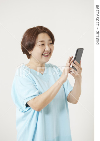 スマートフォンを操作するシニア世代の女性 130591399