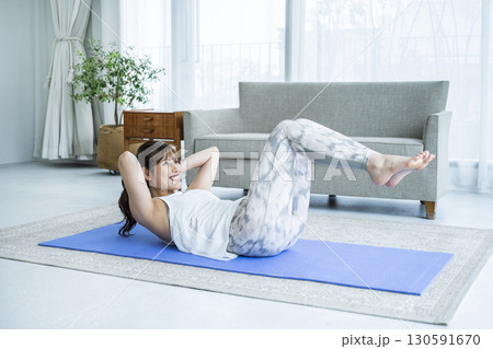 自宅でトレーニングする若い女性 自宅でトレーニングする若い女性 130591670