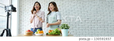 Banner Asian influencer vlogger live review healthy eating lifestyle. Banner Two woman friends blogger vlog happy lifestyle vegetables fruit salad. Two women talk social media vlog with copy space 130591937