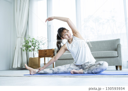 自宅でトレーニングする若い女性 130593934