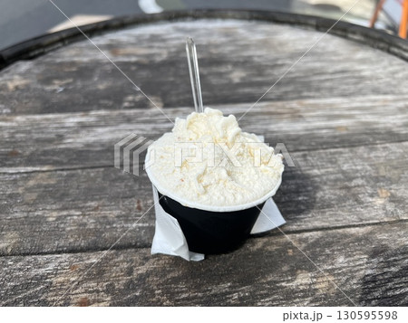 木目のテーブルの上に置かれたカップに入ったアイス 130595598