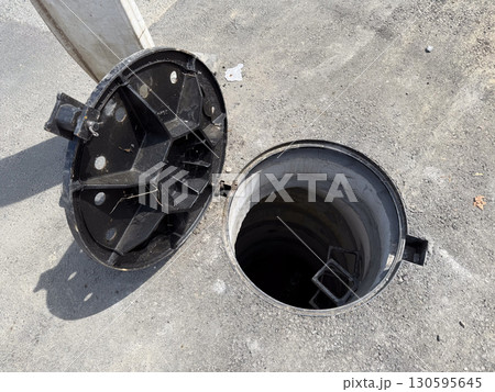 View of open manhole. Urban engineering, construction, and risk management. 130595645