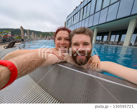 Couple smiling together in the pool . Love, bonding, and joyful summer vacation. Couple smiling together in the pool . Love, bonding, and joyful summer vacation. 130595721