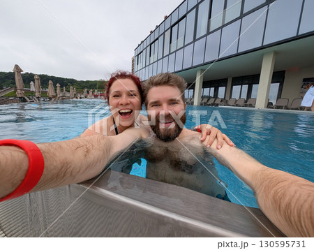 Couple smiling together in the pool. Love, bonding, and joyful summer vacation. Couple smiling together in the pool. Love, bonding, and joyful summer vacation. 130595731