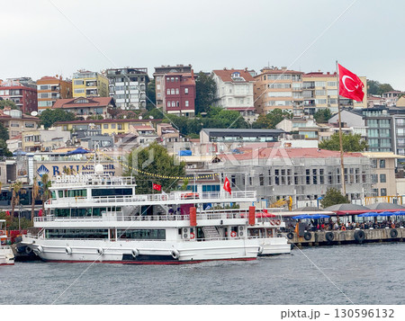 Passenger ferry with Turkish flag at pier in Istanbul. Urban life, transport and Bosphorus maritime culture. 130596132