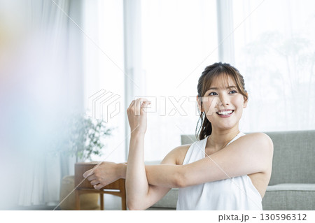 自宅でトレーニングする若い女性 130596312