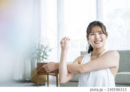 自宅でトレーニングする若い女性 130596313