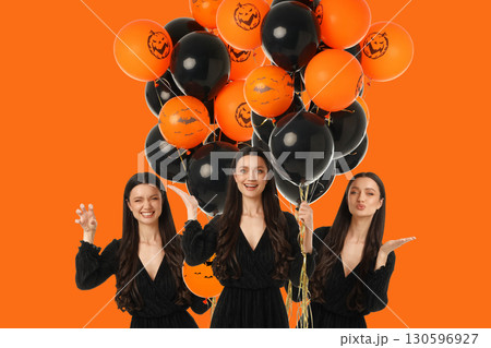 Person with long hair is joyfully holding Halloween balloons 130596927