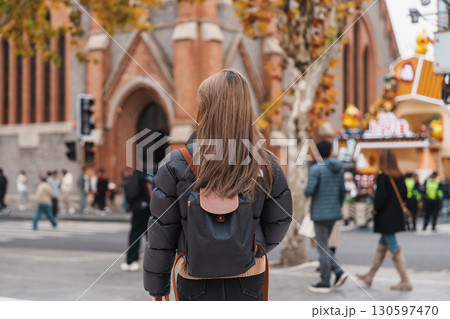 woman traveler visiting in Shanghai, China. Happy Female Tourist sightseeing Shanghai Union Church view in autumn season. landmark and popular for tourism attractions. Travel and vacation 130597470