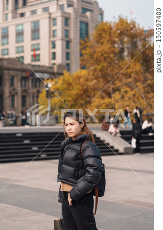 woman traveler visiting in Shanghai, China. Happy Female Tourist sightseeing Shanghai view in The Bund of Shanghai in Autumn season. landmark and popular for tourism attractions. Travel and Vacation 130597480