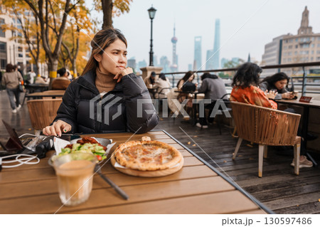 woman traveler visiting in Shanghai, China. Happy Female Tourist enjoy eating and drinking in Restaurant and Coffee bar. landmark and popular for tourism attractions. Travel and vacation concept 130597486
