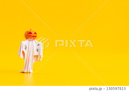 Spooky Pumpkin Head Ghost Figurine on Yellow Background 130597813