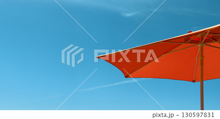 Umbrella and parasol under clear sunny sky. Bright orange and blue sunshade canopy, minimal summer 130597831