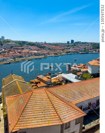 Vertical view of Porto, Portugal with Douro River, cruise boat, traditional red and orange tiled 130597832