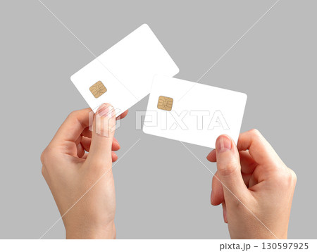Cardholder holding two cards, debit and credit, with a secure grip. Female hand showing both cards Cardholder holding two cards, debit and credit, with a secure grip. Female hand showing both cards 130597925