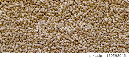 Wood cat litter textured background. Compressed sawdust pellets pattern top view Wood cat litter textured background. Compressed sawdust pellets pattern top view 130598046