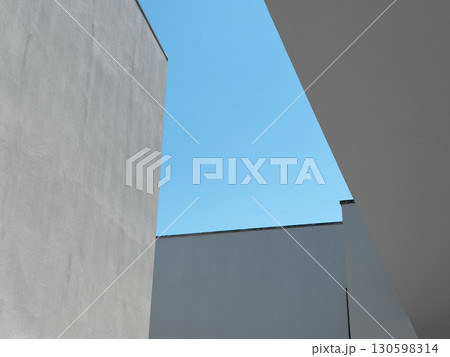 Minimalist view of modern architecture with geometric shapes of white concrete buildings against a Minimalist view of modern architecture with geometric shapes of white concrete buildings against a 130598314