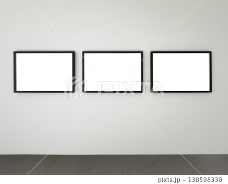 Three black rectangular picture frames mounted on a white wall above a gray floor, modern gallery 130598330