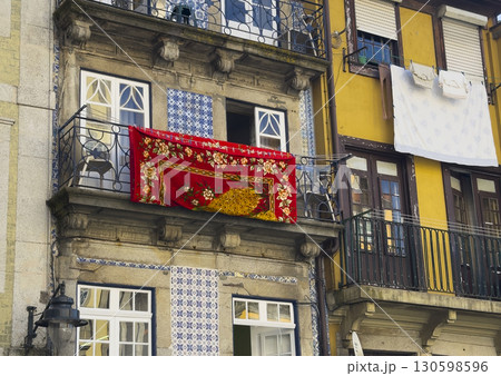 Balconies of traditional houses in Porto with azulejo tiles and colorful facades. A bright red Balconies of traditional houses in Porto with azulejo tiles and colorful facades. A bright red 130598596