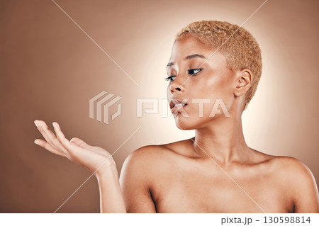 Beauty, skincare and profile of black woman with hand out on mockup in studio for bronze luxury cosmetics. Natural makeup, spa and model on brown background, product placement space and glowing skin. Beauty, skincare and profile of black woman with hand out on mockup in studio for bronze luxury cosmetics. Natural makeup, spa and model on brown background, product placement space and glowing skin. 130598814