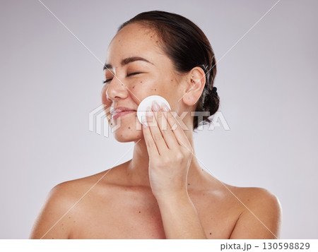 Face, makeup cotton and woman with eyes closed in studio isolated on a gray background. Skincare hygiene, beauty aesthetics and happy female model with facial pad or product for cleaning cosmetics. Face, makeup cotton and woman with eyes closed in studio isolated on a gray background. Skincare hygiene, beauty aesthetics and happy female model with facial pad or product for cleaning cosmetics. 130598829