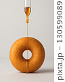 Laminar honey stream passing through donut hole on neutral background 130599089