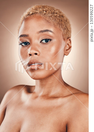 Beauty, skincare and portrait of black woman with glowing skin in studio on brown background. Natural makeup, spa facial promotion and advertising luxury cosmetics on model face with golden shine. Beauty, skincare and portrait of black woman with glowing skin in studio on brown background. Natural makeup, spa facial promotion and advertising luxury cosmetics on model face with golden shine. 130599227
